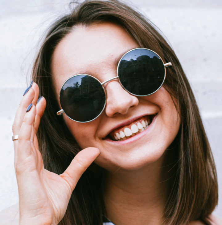 Jeune femme heureuse de porter sa nouvelle paire de lunettes de soleil