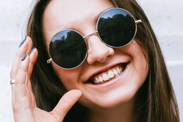 Jeune femme heureuse de porter sa nouvelle paire de lunettes de soleil