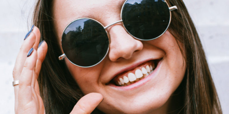 Jeune femme heureuse de porter sa nouvelle paire de lunettes de soleil