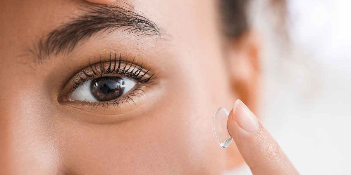 Visage d'une femme aux yeux brun en train de mettre des lentilles de contact